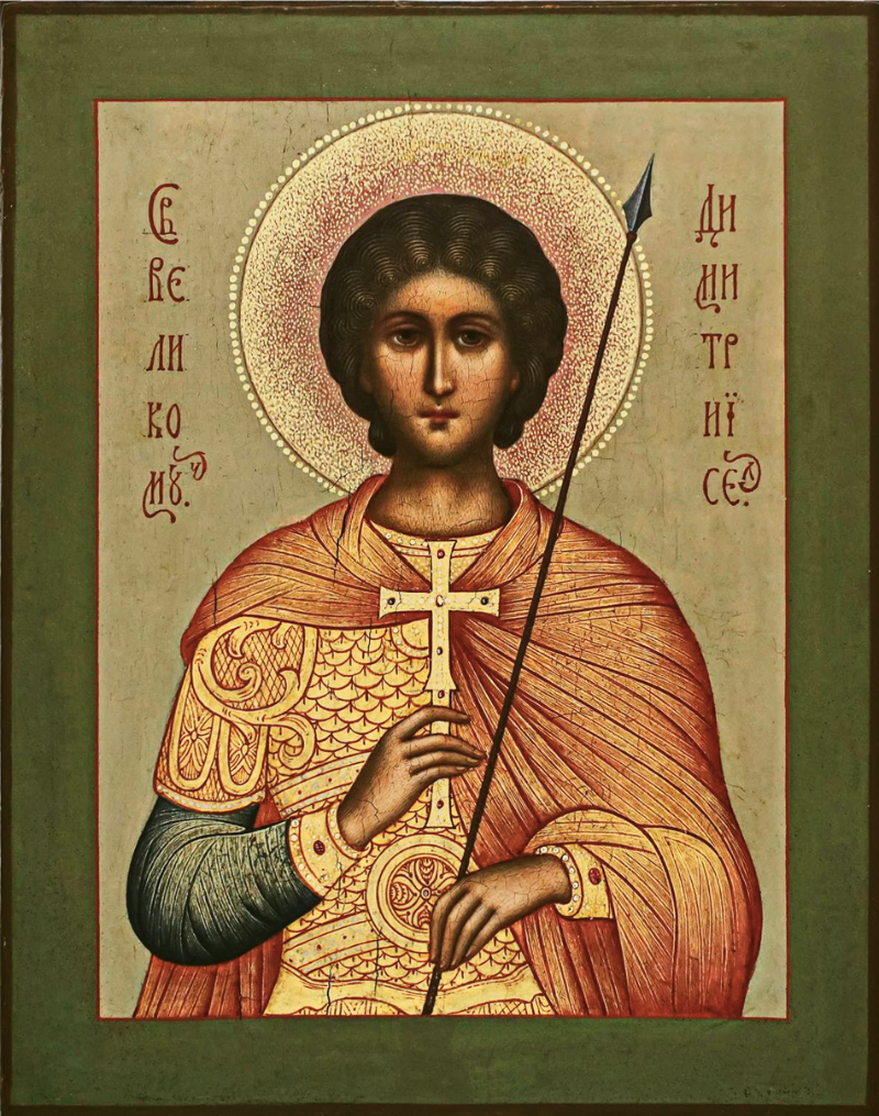 A traditional Eastern Orthodox icon of Saint Demetrius, depicted with a gold halo, wearing a red and gold tunic, holding a spear, and set against a beige background with Cyrillic inscriptions.