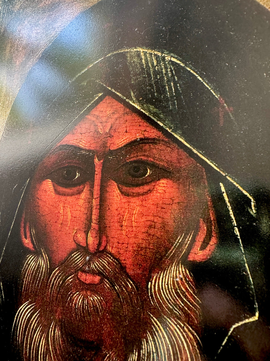 Close-up of a religious icon with a bearded figure wearing a hood. Saint Anthony the Great