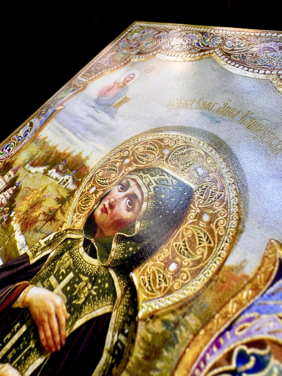 A close-up of an ornate religious icon painting showing a robed figure with a large gold halo, set against a dark background.