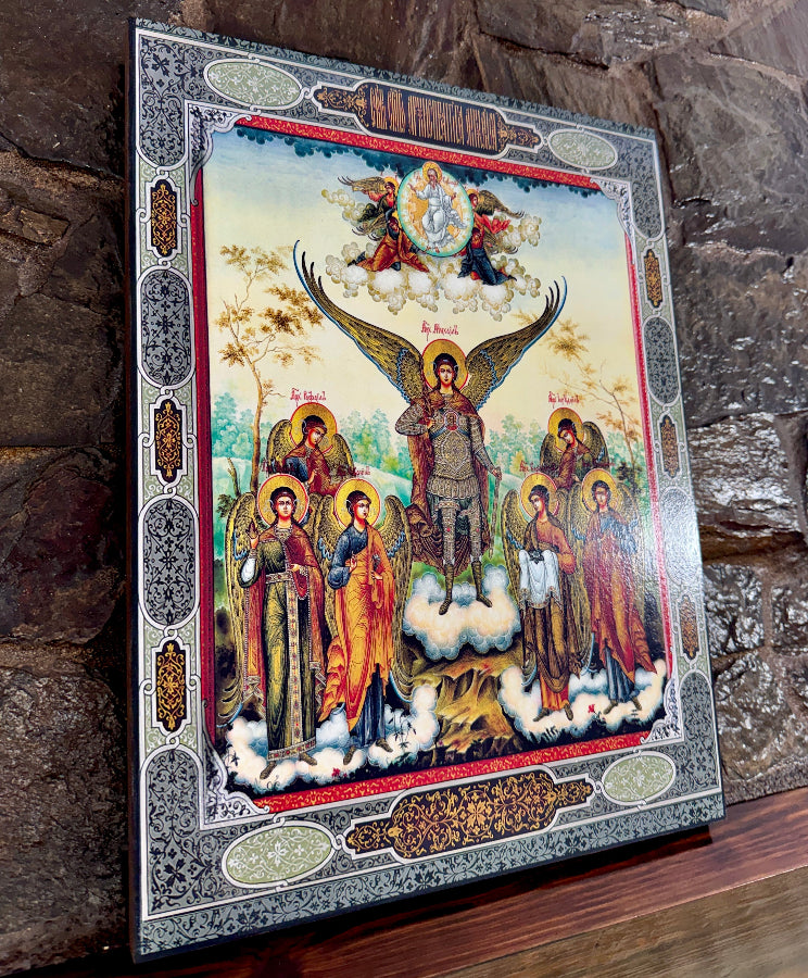 Decorative icon with angelic figures and intricate border on a stone surface